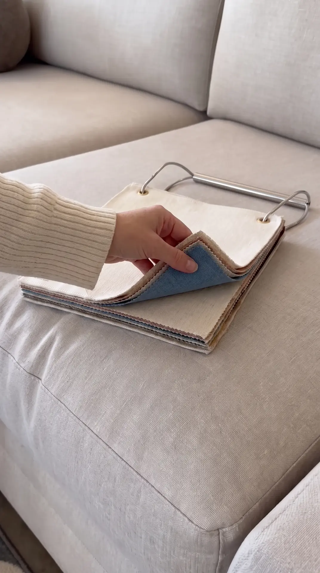 Browsing fabric swatches on a custom sofa in the showroom